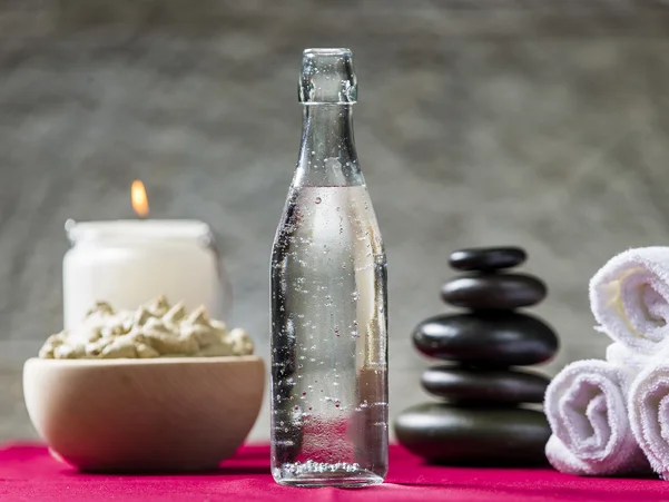 Steklenica mineralne vode, brisače, sveča in skleda