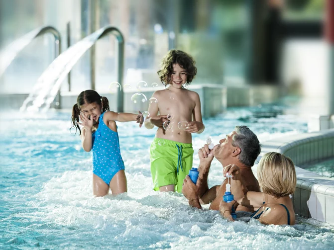 Štiričlanska družina se zabava z milnimi mehurčki v notranjem vodnem parku