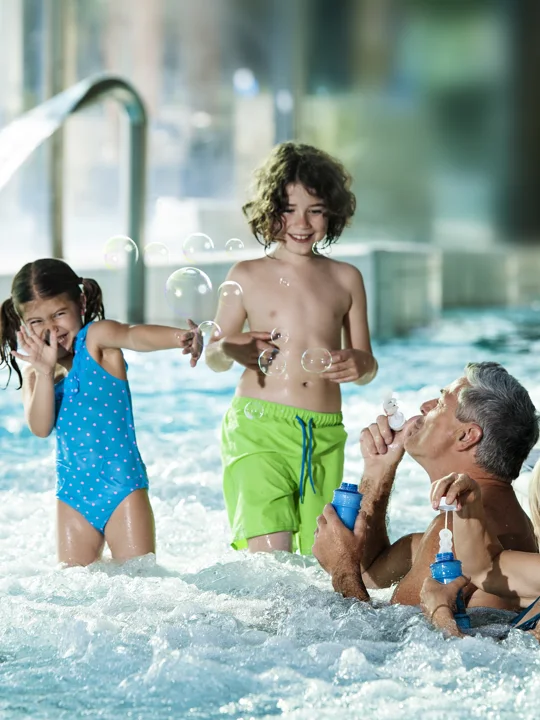 Štiričlanska družina se zabava z milnimi mehurčki v notranjem vodnem parku