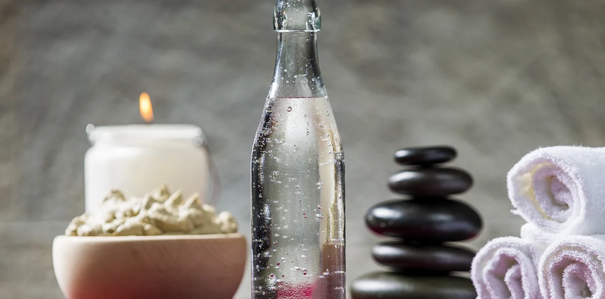 Steklenica mineralne vode, brisače, sveča in skleda