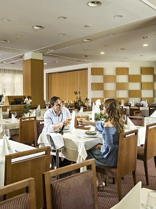 Par sedi za obloženo mizo in obeduje v hotelski restavraciji