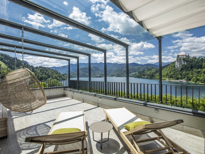Terasa z dvema ležalnikoma, mizico, leseno klopco in lesenim počivalnikom s pogledom na Blejsko jezero