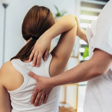 Zdravnik pregleduje pacientkino držo in njen hrbet