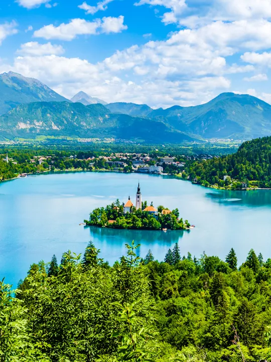 Prekrasen razgled na blejsko jezero, okoliške hribe in otoček s cerkvijo sredi jezera