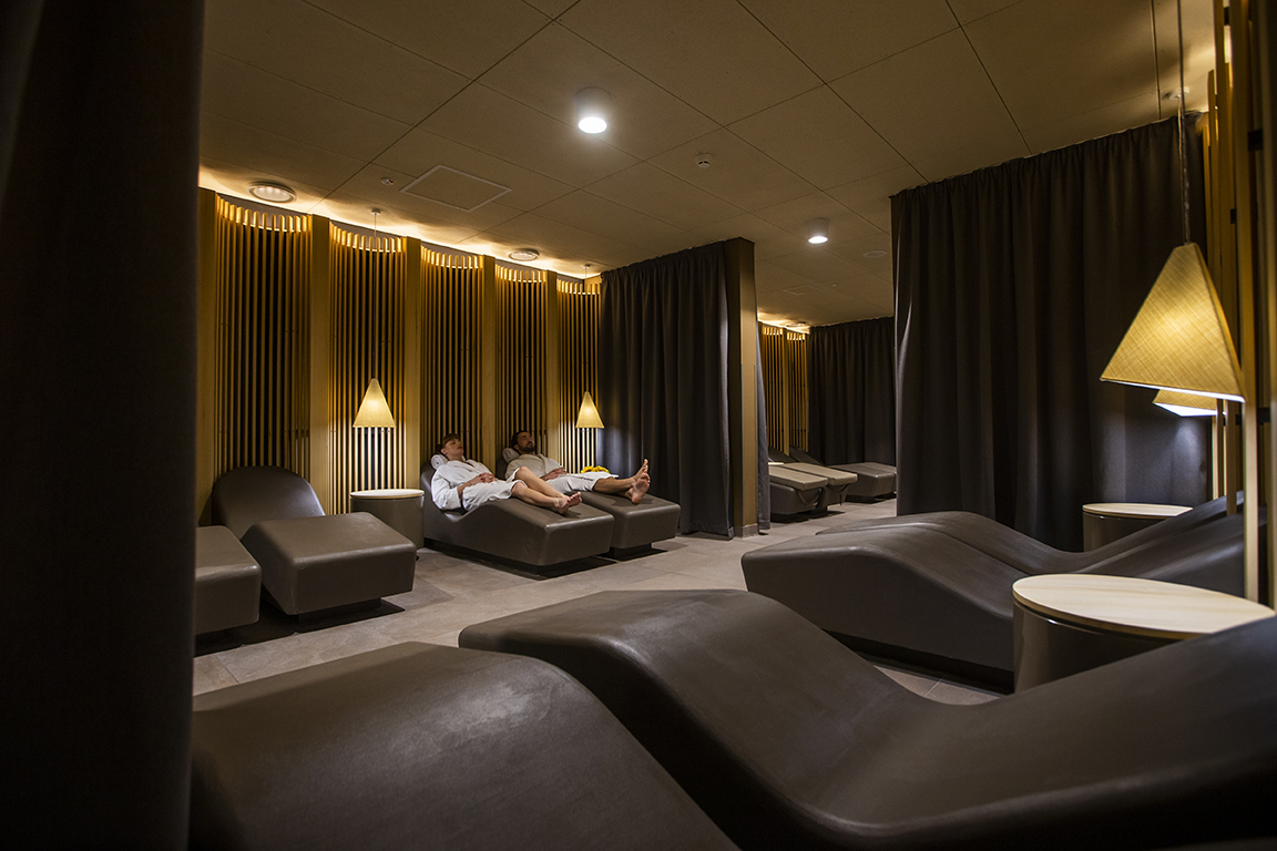 Pogled na sproščujoč lounge in dve osebi, ki se sproščata na ležalnikih