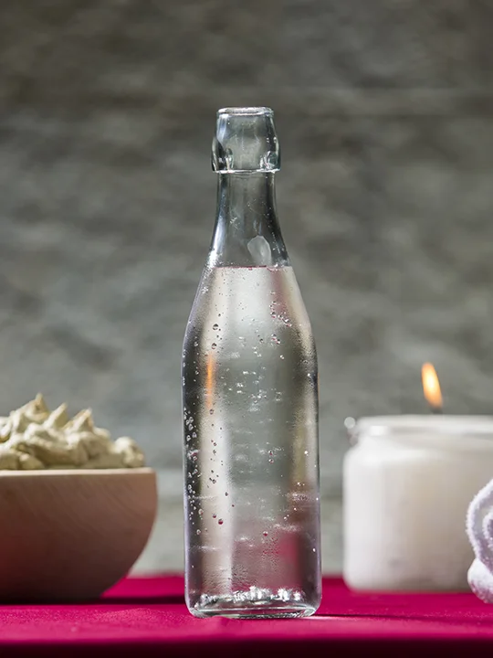 Sveče, steklenica mineralne vode, brisače in skleda s kremo